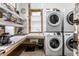 Convenient laundry room with stacked washer and dryer, utility sink, and ample storage space, perfect for everyday chores at 2417 E 80Th E St, Indianapolis, IN 46240