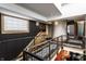 Spacious loft with modern iron railings, an open staircase, and a stylish black accent wall with a unique light fixture at 2417 E 80Th E St, Indianapolis, IN 46240