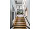 Modern staircase with wooden steps, black railing, and a window showcasing plant accents at 2417 E 80Th E St, Indianapolis, IN 46240