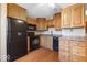 Kitchen with wood cabinets, dark appliances, and hardwood flooring at 3130 Elizabeth St, Indianapolis, IN 46234