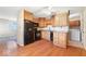 Kitchen featuring wood cabinets, black appliances, and hardwood flooring at 3130 Elizabeth St, Indianapolis, IN 46234