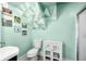 Bathroom showcasing light green walls, modern geometric decor, toilet, and vanity cabinet at 320 15Th St, Columbus, IN 47201