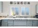 Kitchen featuring blue cabinets, marble countertops, and decorative design touches around the windows at 320 15Th St, Columbus, IN 47201