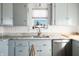 Kitchen featuring blue cabinets, marble countertops, stainless steel appliances, and a sink overlooking window at 320 15Th St, Columbus, IN 47201