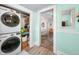 Bright laundry room with stacked washer/dryer, closet shelving, and lovely turquoise paint at 320 15Th St, Columbus, IN 47201