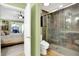 Bathroom featuring a tiled glass shower, toilet, and bedroom entrance at 4139 Bella Ct, Indianapolis, IN 46237