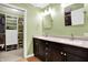 Bathroom featuring double sinks, dark cabinetry, and a walk-in closet at 4139 Bella Ct, Indianapolis, IN 46237