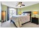 Bedroom featuring green walls, a ceiling fan and light colored carpeting and a large window with curtains at 4139 Bella Ct, Indianapolis, IN 46237