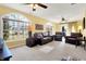 Spacious living room featuring large windows, neutral carpet, ceiling fans and comfortable leather seating arrangement at 4139 Bella Ct, Indianapolis, IN 46237