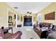 Bright living room with beige carpet, warm yellow walls, and a decorative entertainment center with large screen TV at 4139 Bella Ct, Indianapolis, IN 46237