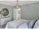 Cozy bedroom with a geometric light fixture, soft green walls, and a white dresser at 4435 Laughter Ln, Indianapolis, IN 46235
