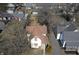Aerial view of a yellow two-story home with a red roof surrounded by trees and other homes at 462 W Broadway St, Greenwood, IN 46142