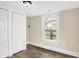 Clean bedroom with neutral colors, wood-look flooring, a closet and a view of exterior of home at 462 W Broadway St, Greenwood, IN 46142