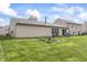 Large, grassy backyard featuring mature trees, a fire pit, and a patio area, great for outdoor activities at 4732 Ashfield Dr, Westfield, IN 46062
