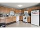 Well-lit kitchen featuring wood cabinets, white appliances, and functional layout at 4732 Ashfield Dr, Westfield, IN 46062