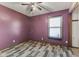 Bedroom with a ceiling fan, gray wood floors, and large window at 477 S Restin Rd, Greenwood, IN 46142