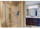 This bathroom has a shower with glass doors, a dual vanity with modern fixtures, and a gray color palette at 4889 Oakleigh Pkwy, Greenwood, IN 46143