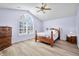 Bedroom with large window, ceiling fan, hardwood floors, and wood furniture at 5316 Twin Bridge Blvd, Indianapolis, IN 46239