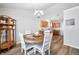 Dining area with a wooden table, white chairs, and view to the kitchen at 5316 Twin Bridge Blvd, Indianapolis, IN 46239