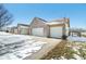 Attached three-car garage with a brick exterior, complemented by a snow-covered lawn and a sunny blue sky at 5316 Twin Bridge Blvd, Indianapolis, IN 46239