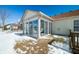 A sunroom-style patio provides a bright and inviting space to enjoy views of the snowy yard at 5316 Twin Bridge Blvd, Indianapolis, IN 46239