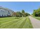 Beautiful backyard featuring a walking path, well-manicured lawn, and mature trees on a bright, sunny day at 5682 Castor Way, Noblesville, IN 46062
