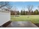 A green backyard with a concrete patio and bare trees in view at 5682 Castor Way, Noblesville, IN 46062