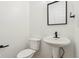 A bright and simple bathroom with a pedestal sink and a classic black framed mirror at 5682 Castor Way, Noblesville, IN 46062
