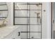 Modern shower with black framing and white tile, complemented by brass shower fixtures at 5682 Castor Way, Noblesville, IN 46062