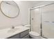 Clean bathroom featuring a round mirror, a shower with sliding glass doors, and a white vanity at 5682 Castor Way, Noblesville, IN 46062