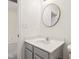 Cozy bathroom showcasing a round mirror and a gray vanity with white countertop at 5682 Castor Way, Noblesville, IN 46062