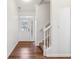 Bright foyer with hardwood flooring, white trim, and a carpeted staircase at 5682 Castor Way, Noblesville, IN 46062