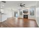Open-concept living room with a fireplace, large windows, and modern ceiling fan at 5682 Castor Way, Noblesville, IN 46062