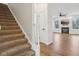 Cozy living room with a fireplace, large windows, and staircase view at 5682 Castor Way, Noblesville, IN 46062