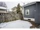 Backyard with a wooden fence and house siding, covered in a blanket of fresh snow at 5736 Central Ave, Indianapolis, IN 46220