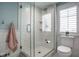 Bathroom featuring a glass enclosed shower and toilet with shuttered window view at 5736 Central Ave, Indianapolis, IN 46220