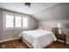 Attic bedroom featuring a bed with pink pillows, a nightstand with a lamp, and hardwood floors at 5736 Central Ave, Indianapolis, IN 46220