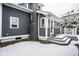 Charming gray home exterior with a brick chimney, sunroom entrance, and snowy surroundings at 5736 Central Ave, Indianapolis, IN 46220