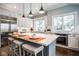 Well-lit kitchen featuring an island with seating, stainless appliances, and white cabinetry at 5736 Central Ave, Indianapolis, IN 46220