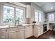 Bright kitchen featuring white cabinets, subway tile backsplash, and a stainless steel sink at 5736 Central Ave, Indianapolis, IN 46220