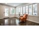 Bright living room featuring an orange chair, large windows, and beautiful hardwood floors at 5736 Central Ave, Indianapolis, IN 46220