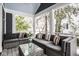 Relaxing screened-in porch with comfortable seating and a glass coffee table and snowy views at 5736 Central Ave, Indianapolis, IN 46220