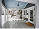 Charming porch featuring an entryway, stained wood flooring, white columns, and neutral decor at 5736 Central Ave, Indianapolis, IN 46220