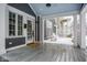 Inviting covered porch with gray wood flooring, white columns, seating and stylish decor at 5736 Central Ave, Indianapolis, IN 46220