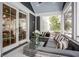 Screened-in porch with cozy seating and a glass coffee table and wintery views at 5736 Central Ave, Indianapolis, IN 46220
