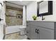 Updated bathroom featuring a shower/tub combination, gray vanity, and dark hardware at 5814 Beechwood Ave, Indianapolis, IN 46219