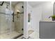 Updated bathroom with gray vanity, tile shower, and view into adjacent bedroom at 5814 Beechwood Ave, Indianapolis, IN 46219