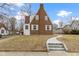 View of the house featuring brick walls, white accents, and a well-manicured front lawn at 5814 Beechwood Ave, Indianapolis, IN 46219