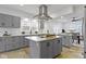 Bright kitchen features gray cabinetry, stainless steel hood vent, and an island with a white countertop at 5814 Beechwood Ave, Indianapolis, IN 46219
