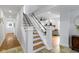 Staircase features wooden steps, white risers, and black railings, offering a modern touch to the home at 5814 Beechwood Ave, Indianapolis, IN 46219
